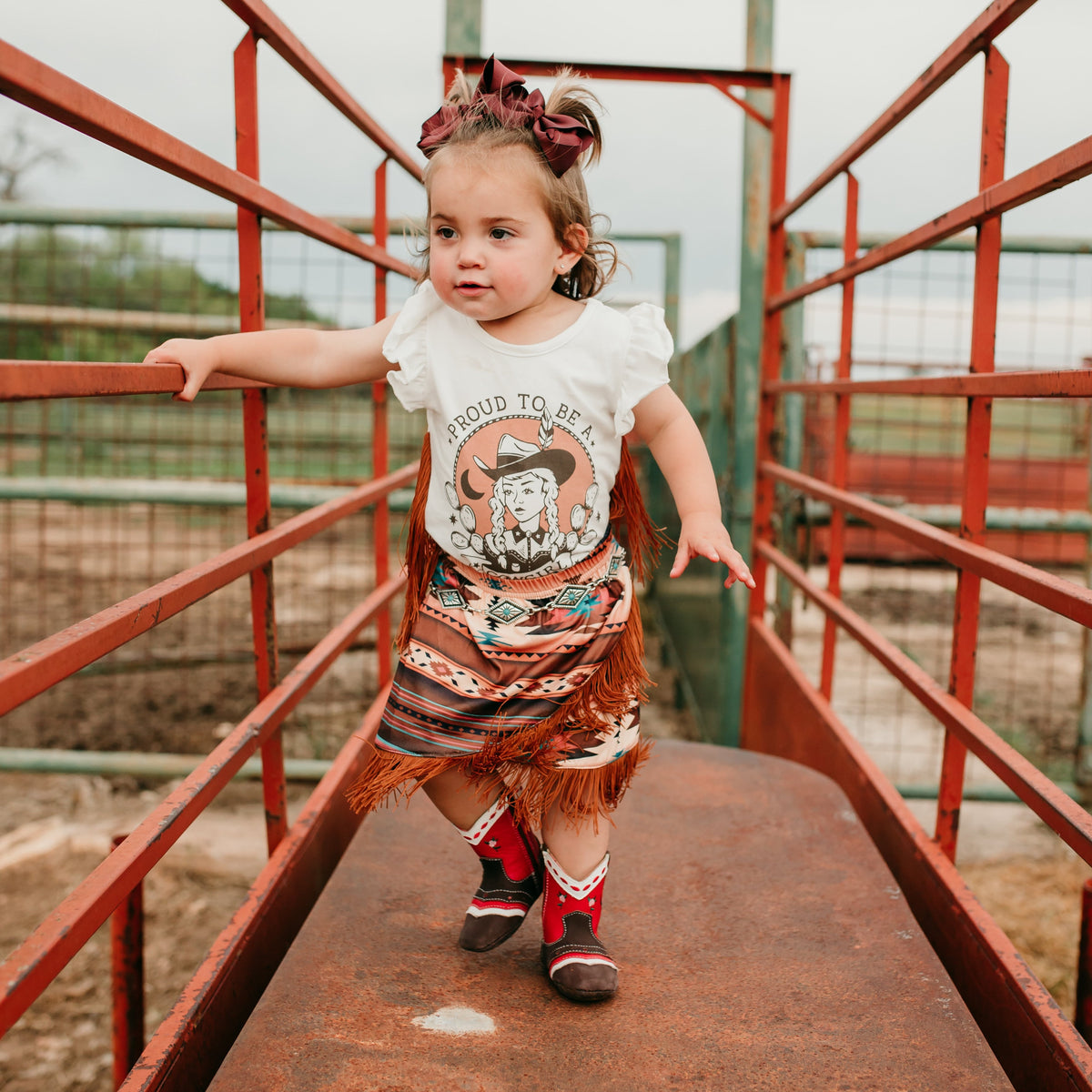 Proud to be a Cowgirl Fringe Onesie, 0-2T ( Sold pack of 8)